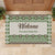 A custom doormat featuring a green Fijian Tribal Tapa pattern with a personalized family name at the center